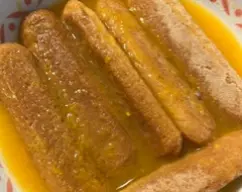 Step <p>Ahora, vamos a remojar los bizcochos en el zumo de naranja. Que queden bien empapados.</p> illustration